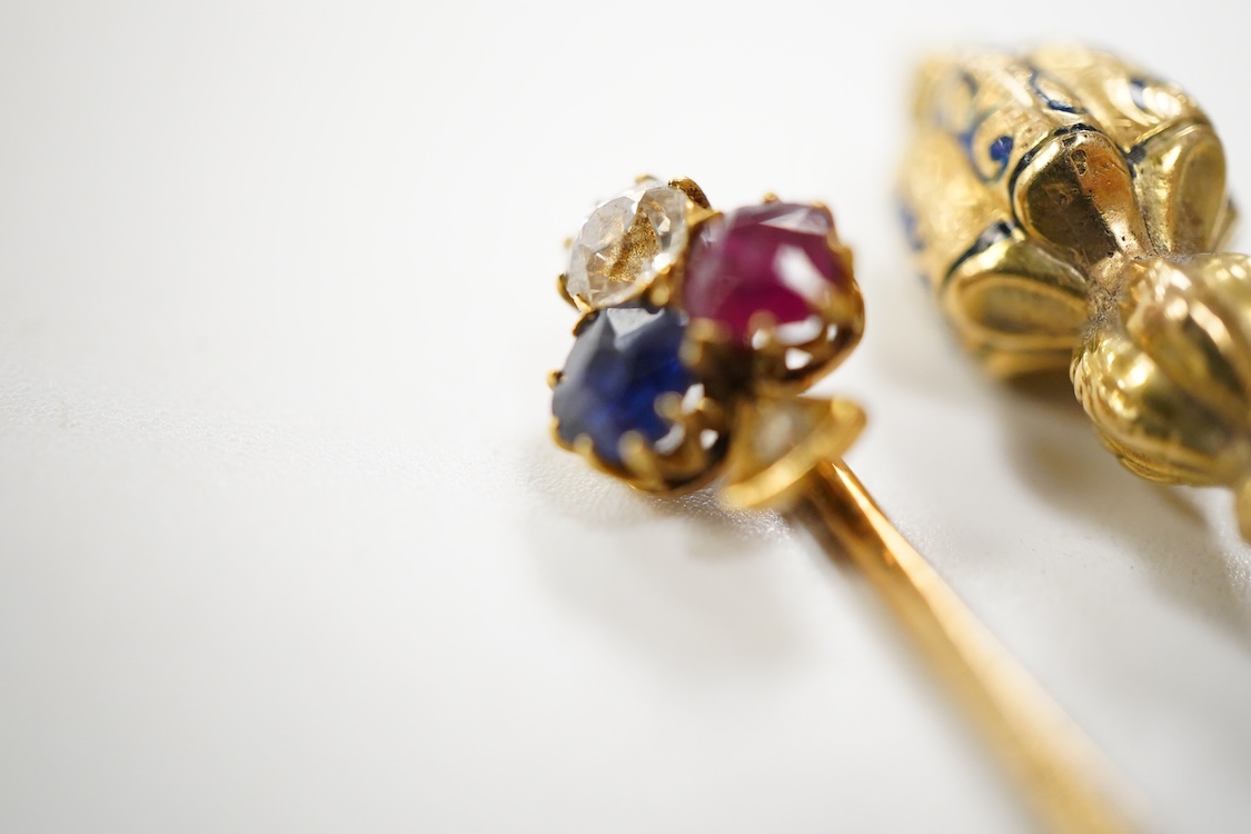 An early 20th century Viennese yellow metal, ruby, diamond and sapphire set 'clover' stick pin, 68mm, together with a yellow metal and blue enamel set stick pin.
